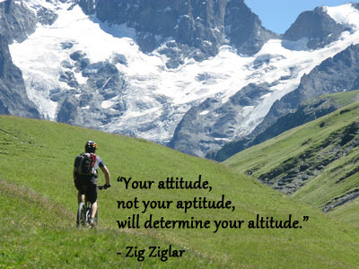 Mountain biking in snow capped mountains with Zig Ziglar quote about attitude.